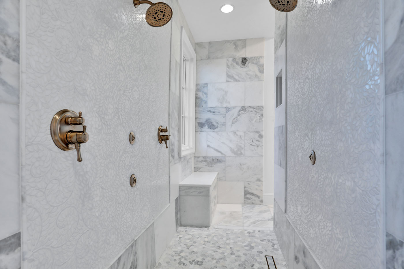 A newly renovated shower with tile on the floors, walls, and floors.