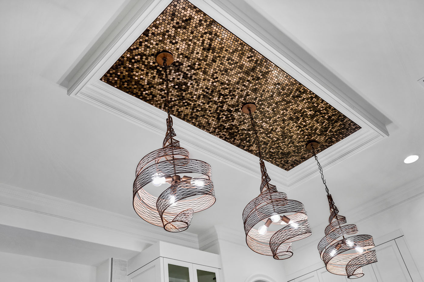 A modern light fixture by Footprints Bath and Tile Raleigh with modern, beautiful tiling.