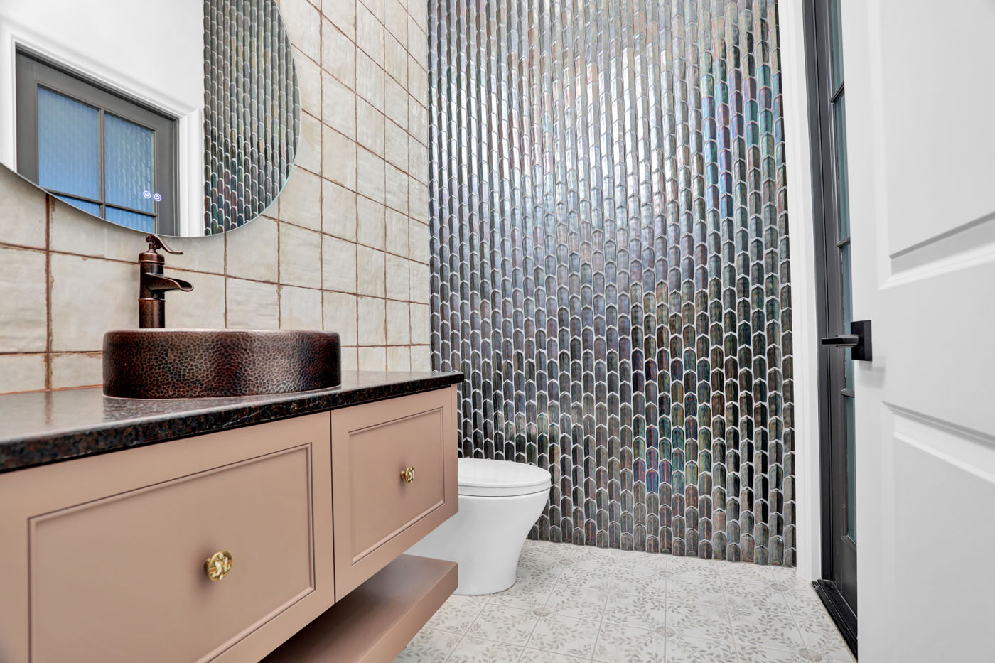 A refinished bathroom by Footprints Bath and Tile Raleigh with modern, metallic tiling.