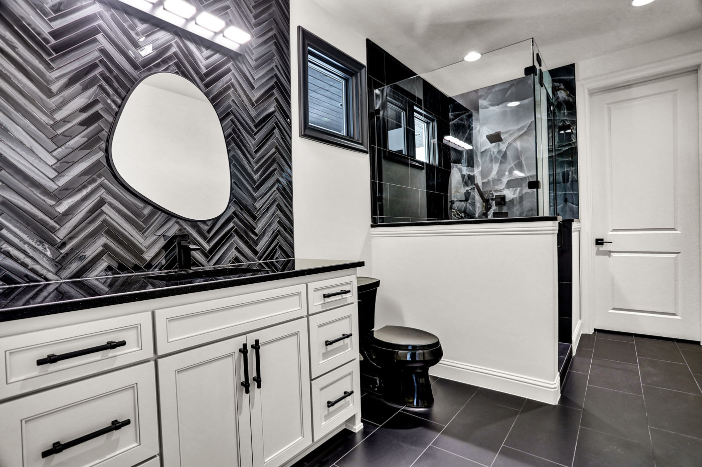 A black and white herringbone tile recently installed by Footprints Bath and Tile Raleigh.