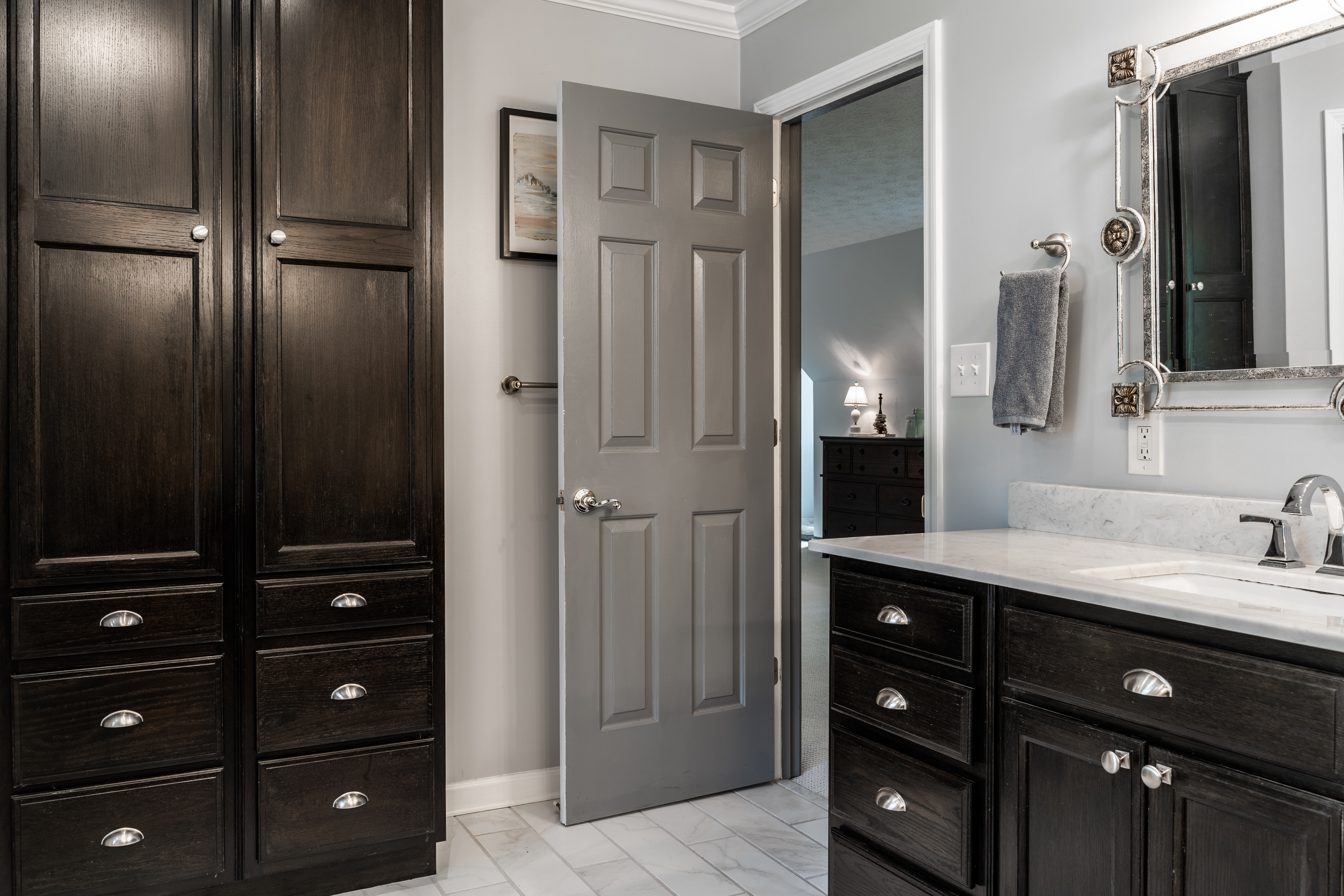 A bathroom with black colored cabinetry along the wall and on the vanity - installed by Footprints Bath and Tile Richmond, VA.