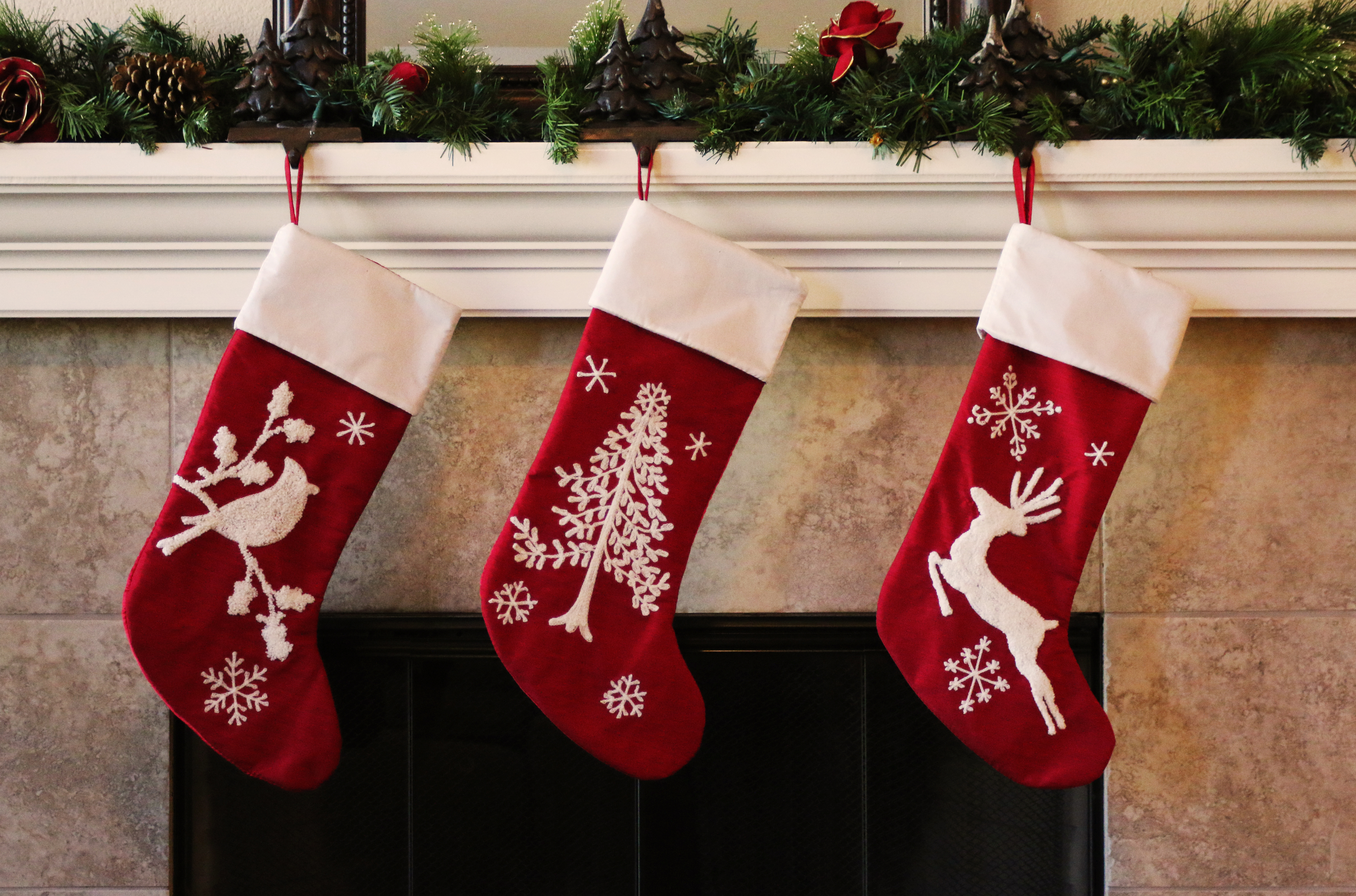 Holiday stockings hanging on a fireplace -  learn about holiday tile upgrades in Raleigh, NC with Footprints Bath and Tile.