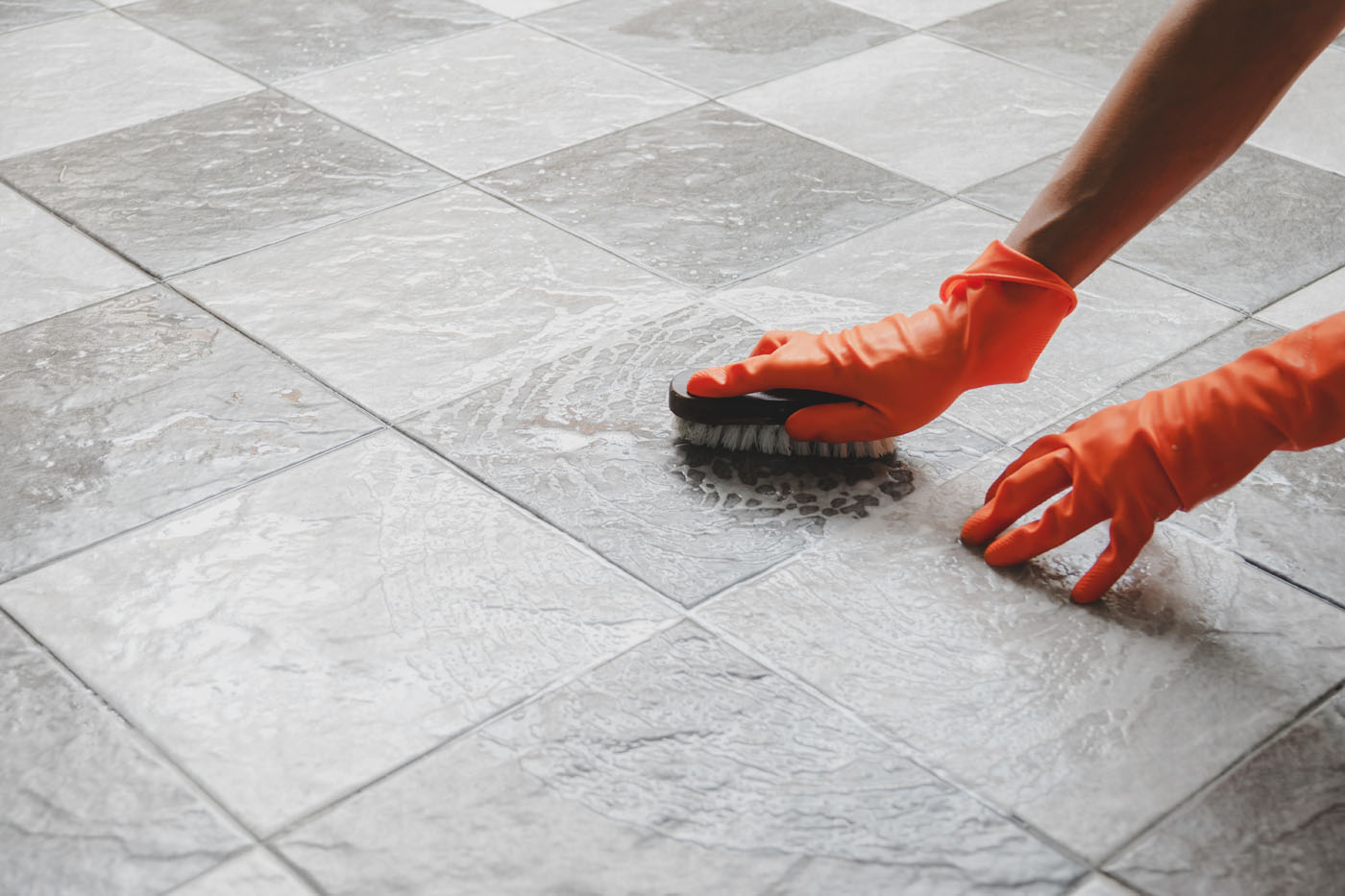 A Footprints Bath and Tile expert cleaning tile with Loba products.