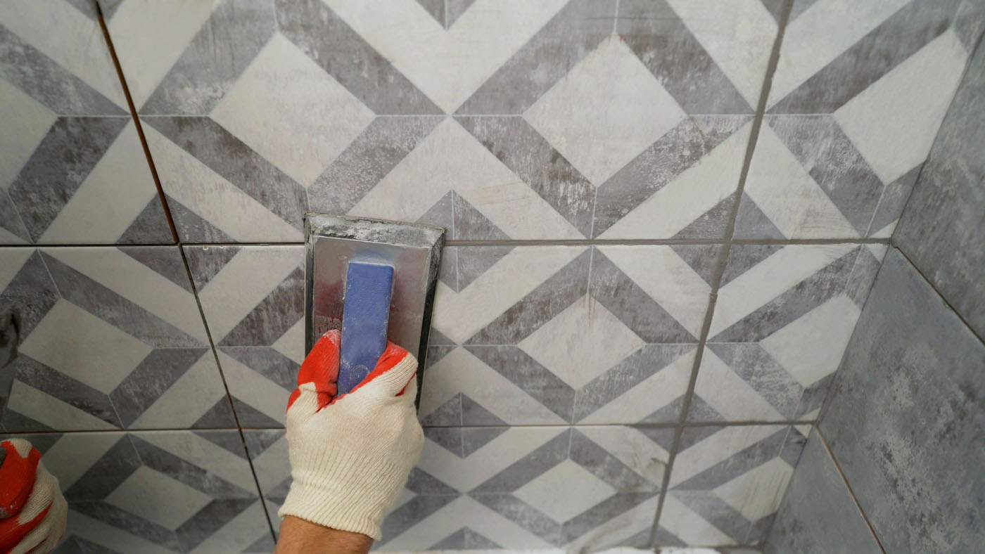 A Footprints Bath and Tile professional installing tile in a bathroom remodel.