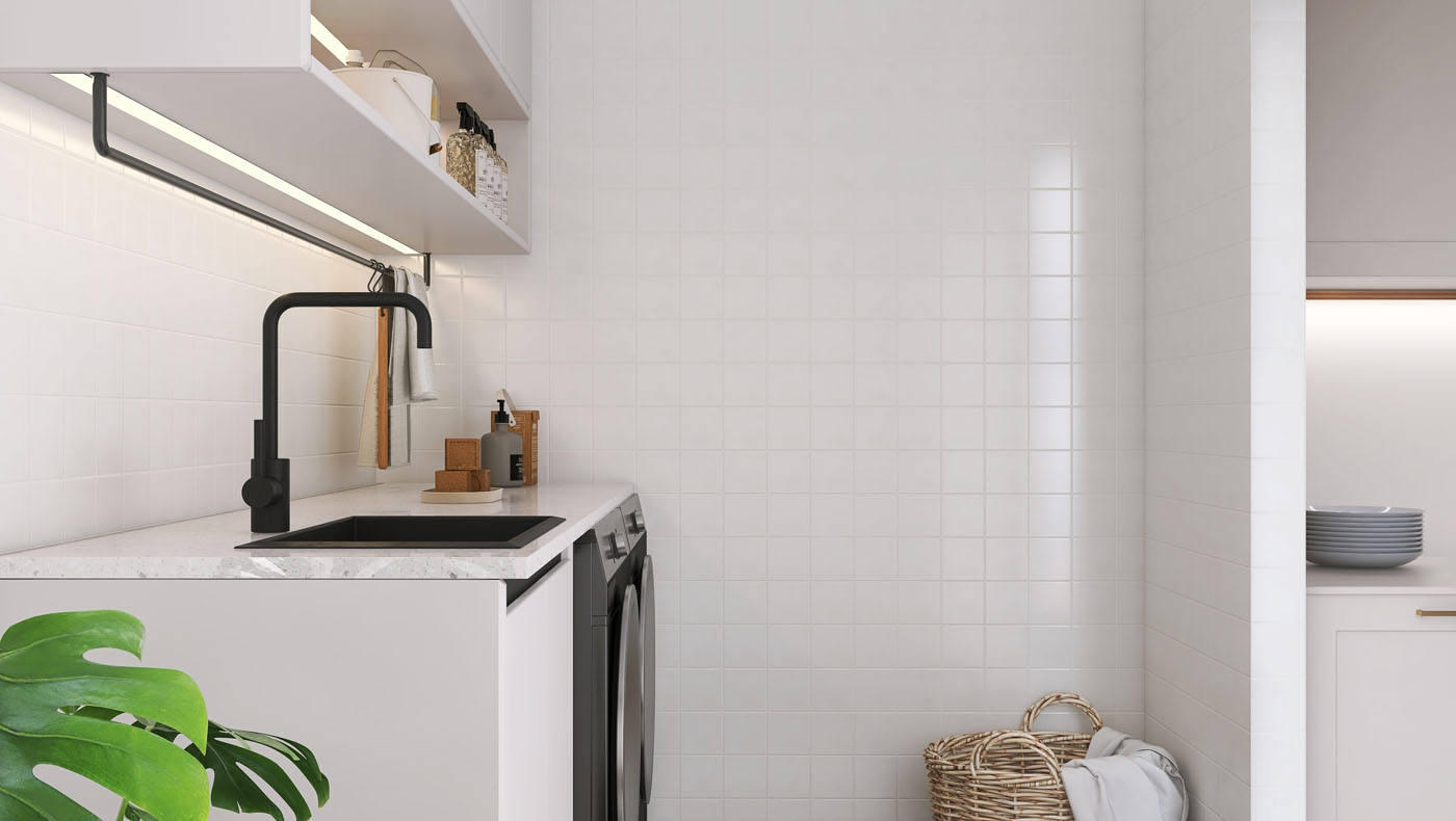 An image of a laundry room with tile backsplashes and sink.