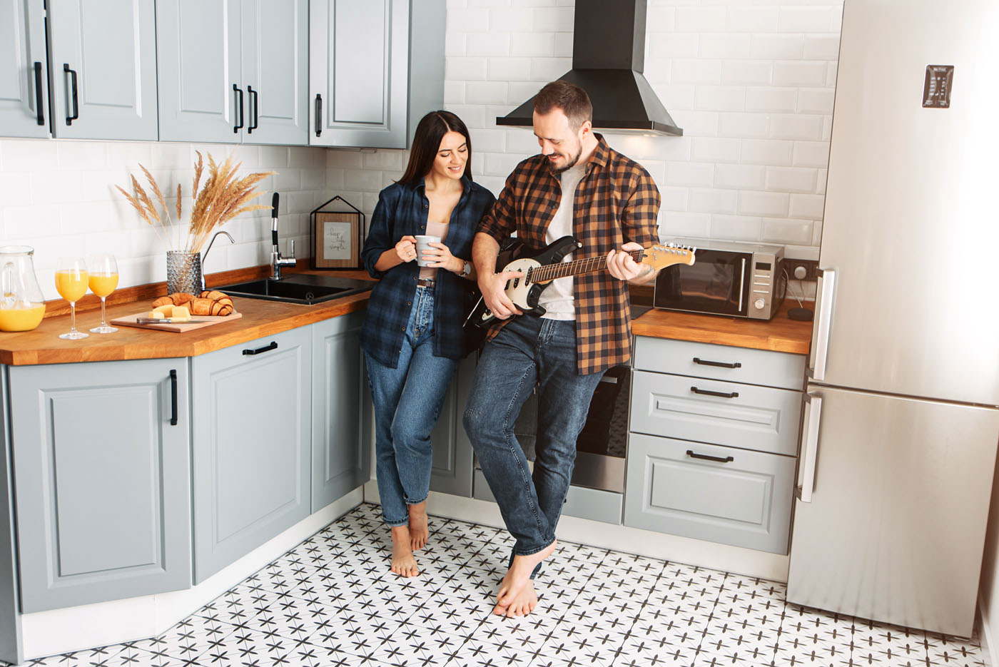 Two homeowners enjoying the new backsplash in their renovated kitchen.