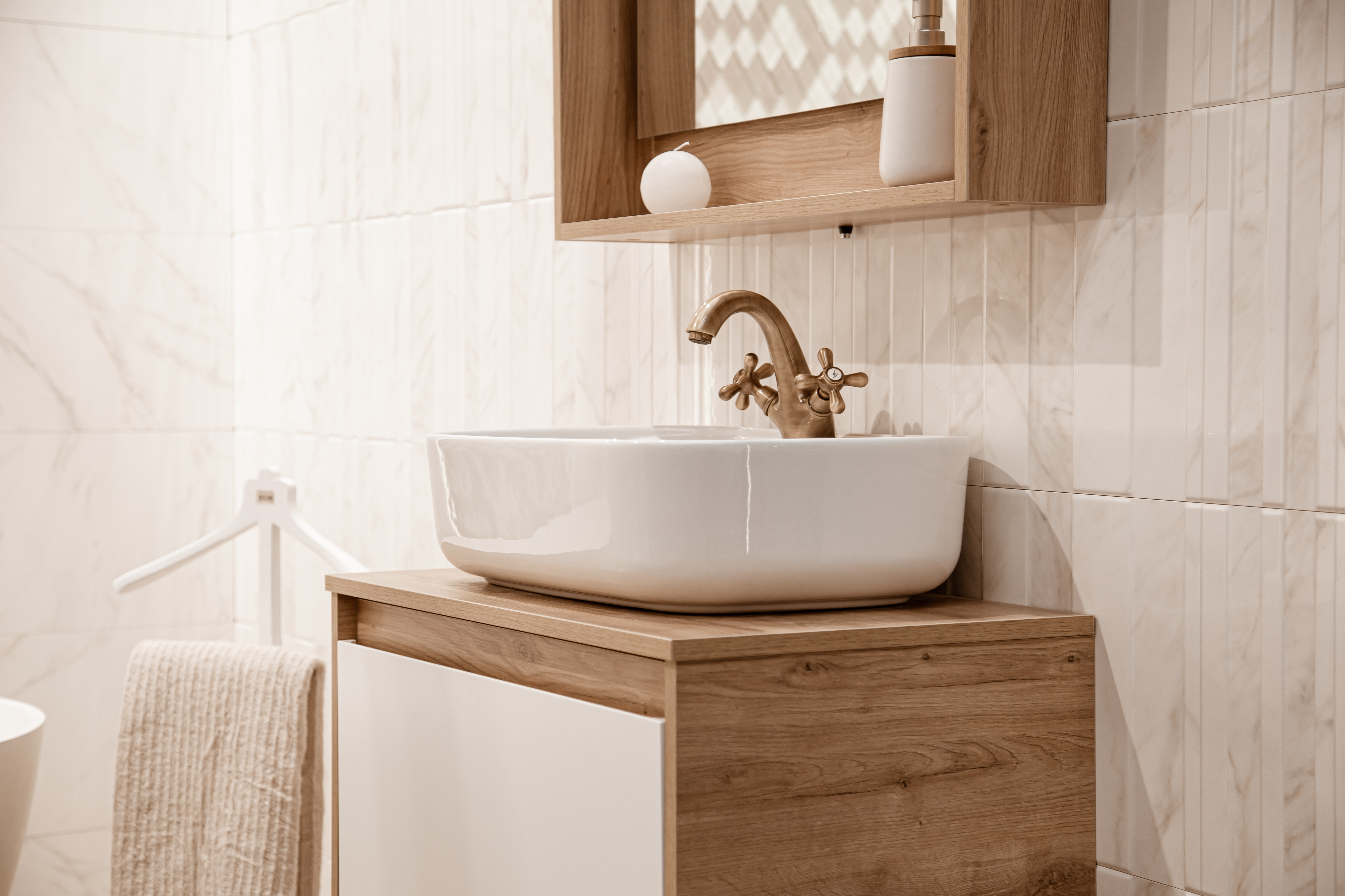 A close up of a sink and tiled walls from a newly installed powder room renovations from Footprints Bath and Tile.